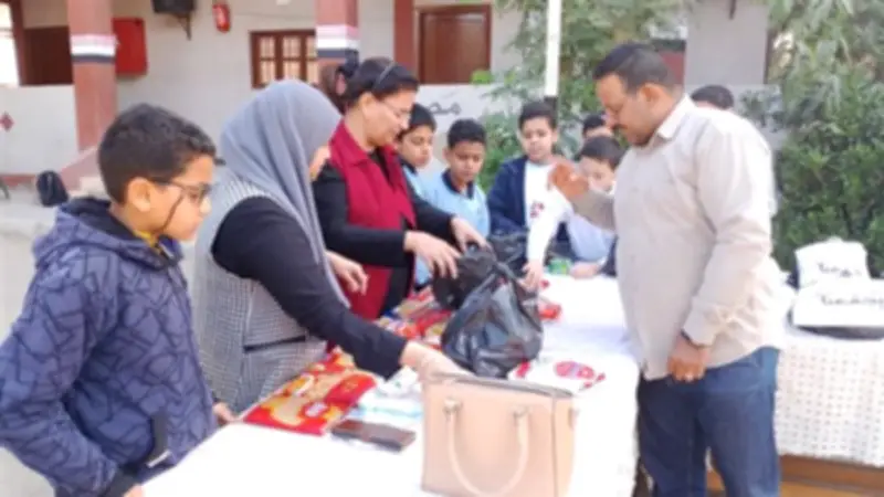 تلاميذ مدرسة أرمنت الابتدائية يشاركون في تعبئة شنط رمضان بالأقصر
