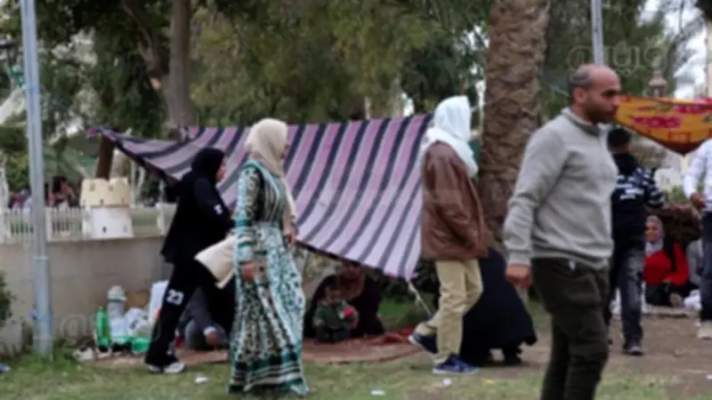 زوار الحديقة الدولية يلجأون للقبعات والملايات هربًا من الأمطار في ثاني أيام العيد