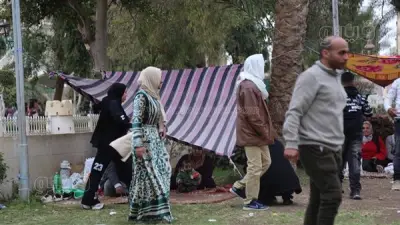 زوار الحديقة الدولية يلجأون للقبعات والملايات هربًا من الأمطار في ثاني أيام العيد