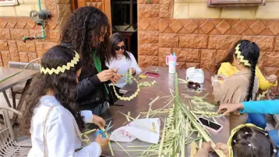 تيجان وصلبان من السعف تزين احتفالات أحد الشعانين بكنيسة الأنبا بيشوي في بورسعيد