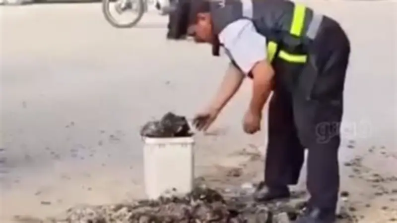 أمين شرطة بالشرقية يزيل مخلفات الأسفلت تفادياً لحوادث الطريق