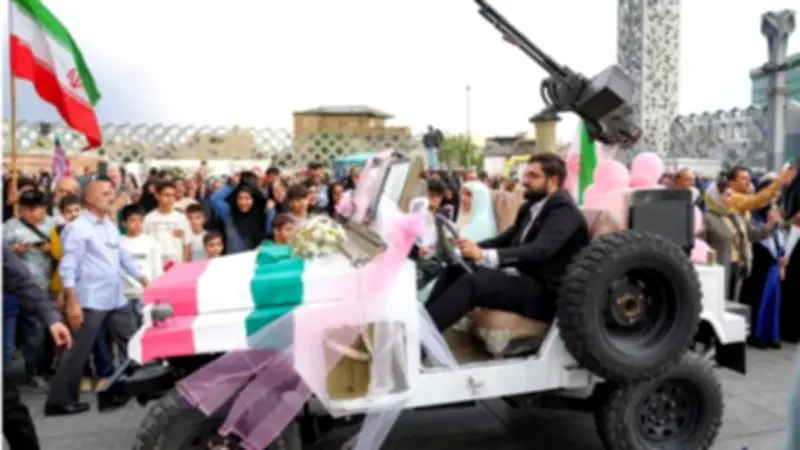 بالدبابات والمدافع: زفاف جماعي لإيرانيين تعهدوا بالتضحية في الحرب