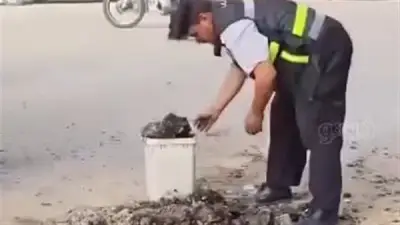 أمين شرطة بالشرقية يزيل مخلفات الأسفلت تفادياً لحوادث الطريق