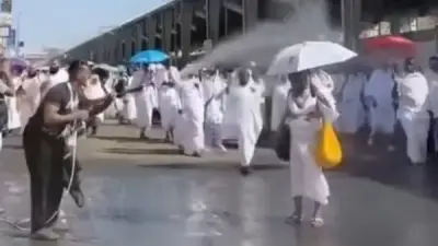 شاب يرش المياه على الحجاج لتخفيف حرارة الجو في مشهد إنساني مؤثر