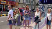 سياح يلتقطون صورًا تذكارية مع صور الرؤساء بكورنيش الإسكندرية