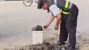 أمين شرطة بالشرقية يزيل مخلفات الأسفلت تفادياً لحوادث الطريق