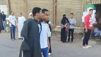 طالب يساند صديقه على عكاز أثناء دخول لجنة الثانوية العامة بقنا